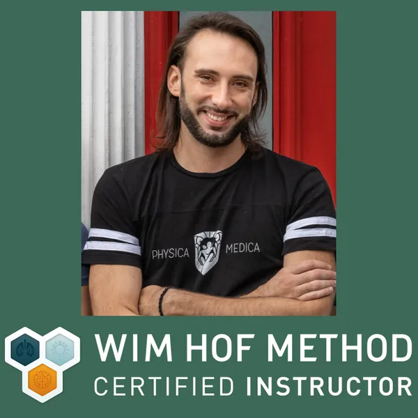 Male practitioner in branded black Physica Medica shirt with WIM HOF Method certification badge, smiling at camera